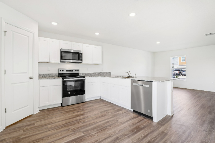 A kitchen with white cabinets.