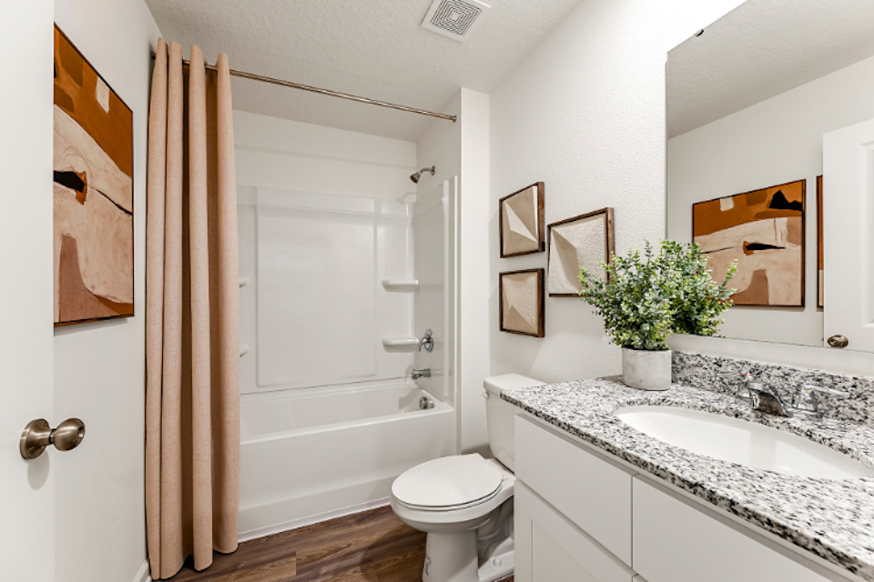 A bathroom with a tub sink and toilet.