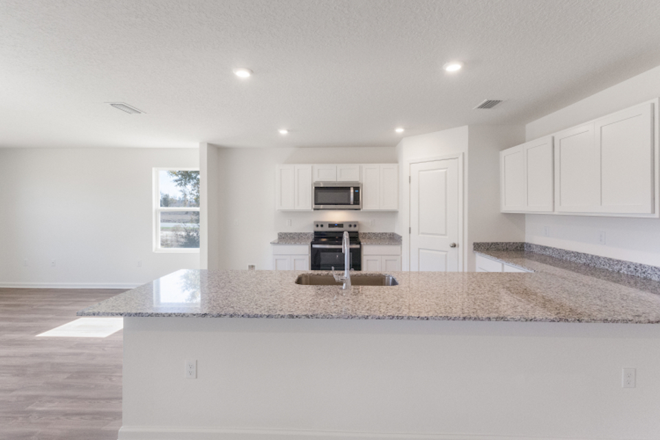 A kitchen with white cabinets.
