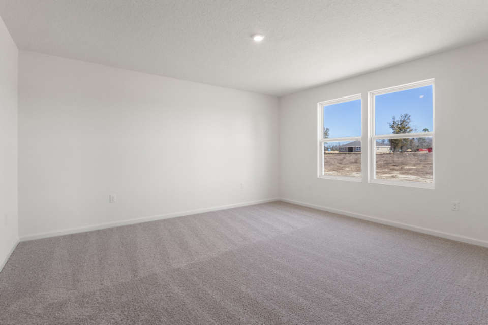 A room with a window and a carpet.