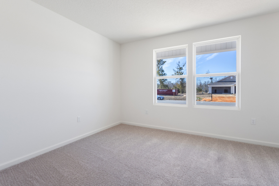 A room with a window and a white wall with a view of the water.