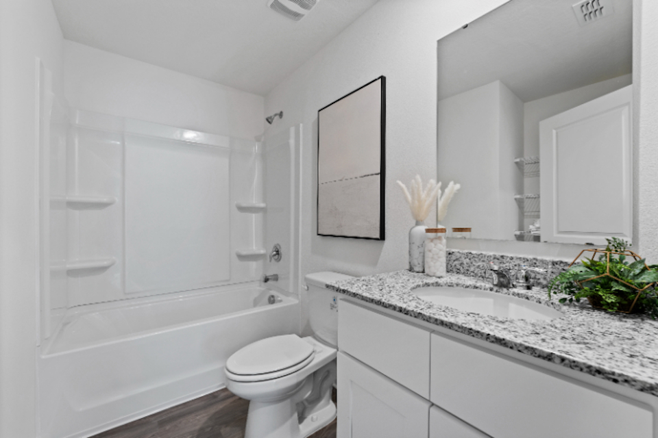 A bathroom with a tub sink and toilet.