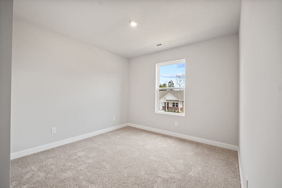 A room with a window and a carpet.