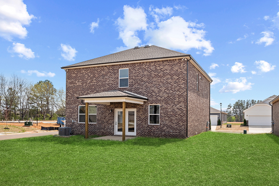 A brick house with a grass yard.