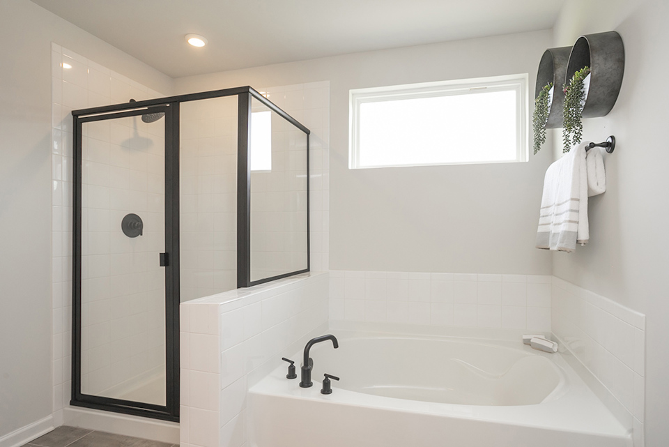 A bathroom with a tub and a mirror.