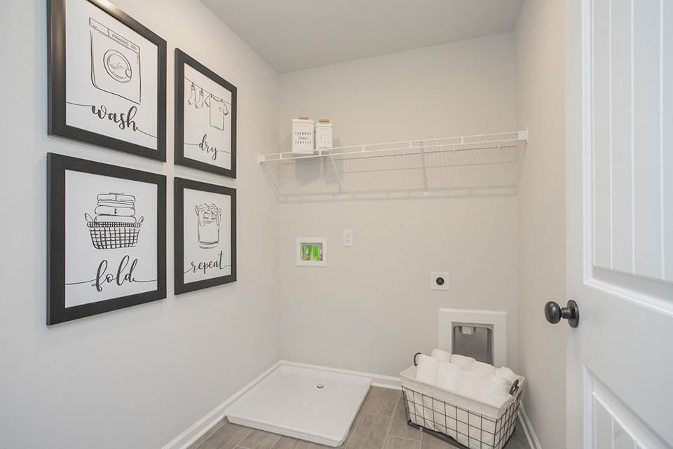 A bathroom with a tub and a shelf with pictures on it.