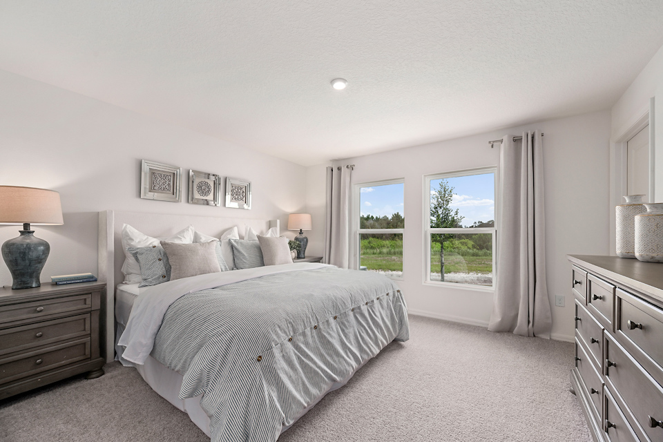 A bedroom with a large window.