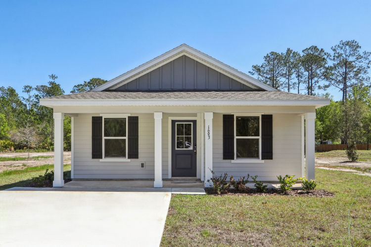 A small white house with Ralph J. Bunche House in the background.