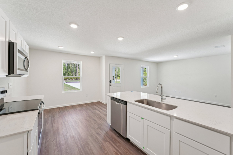 A kitchen with white cabinets.