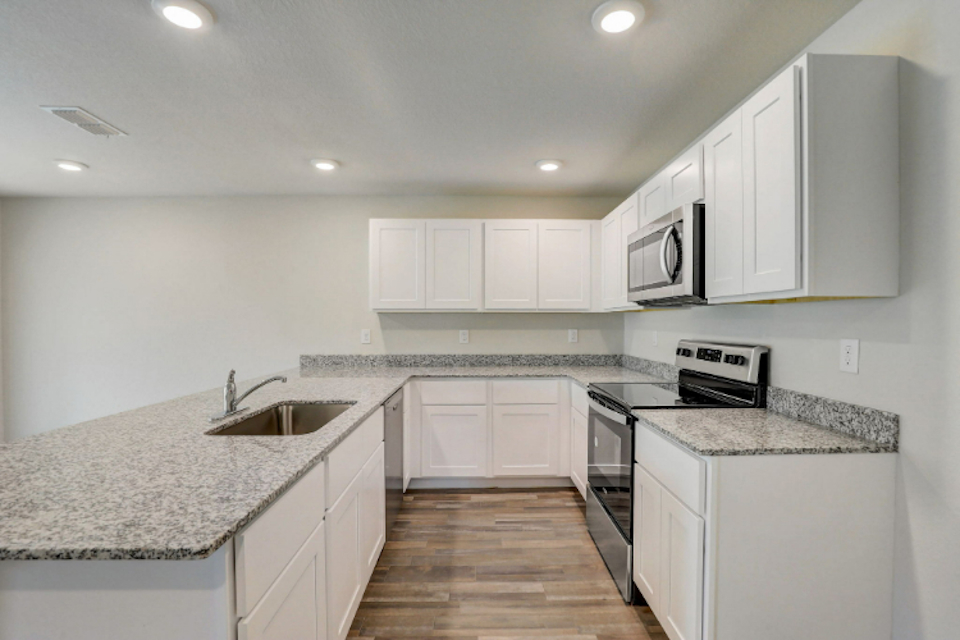 A kitchen with white cabinets.