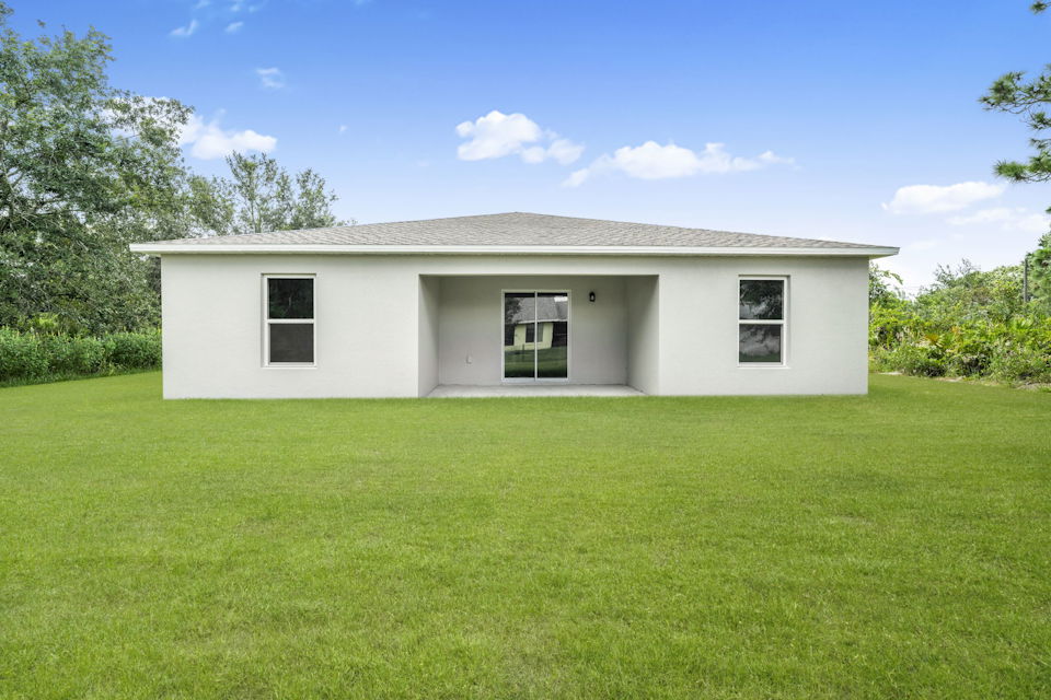 A white house with a grass yard.