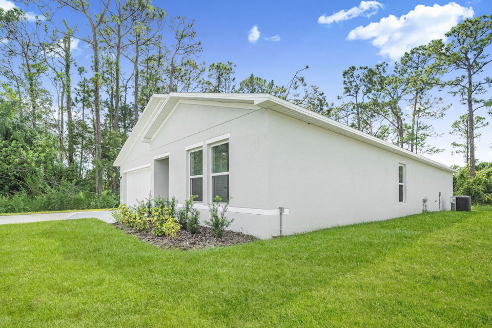 A white house with a lawn.