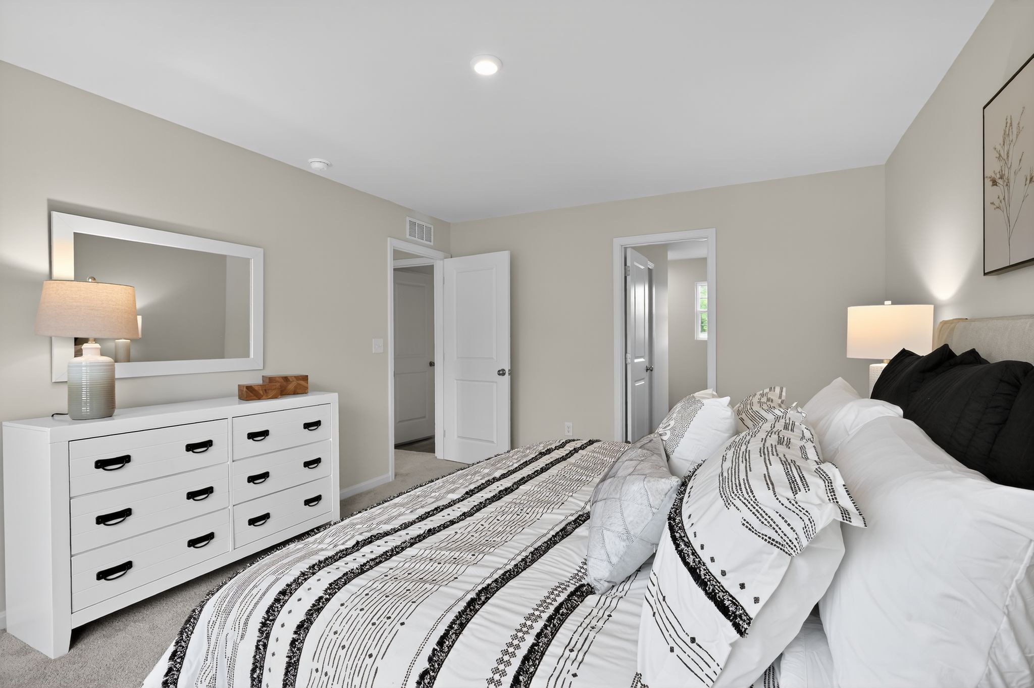 A bedroom with a bed and a mirror.