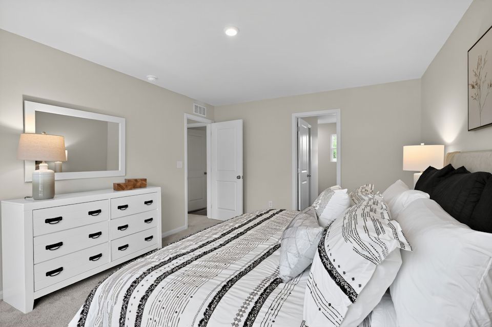 A bedroom with a bed and a mirror.