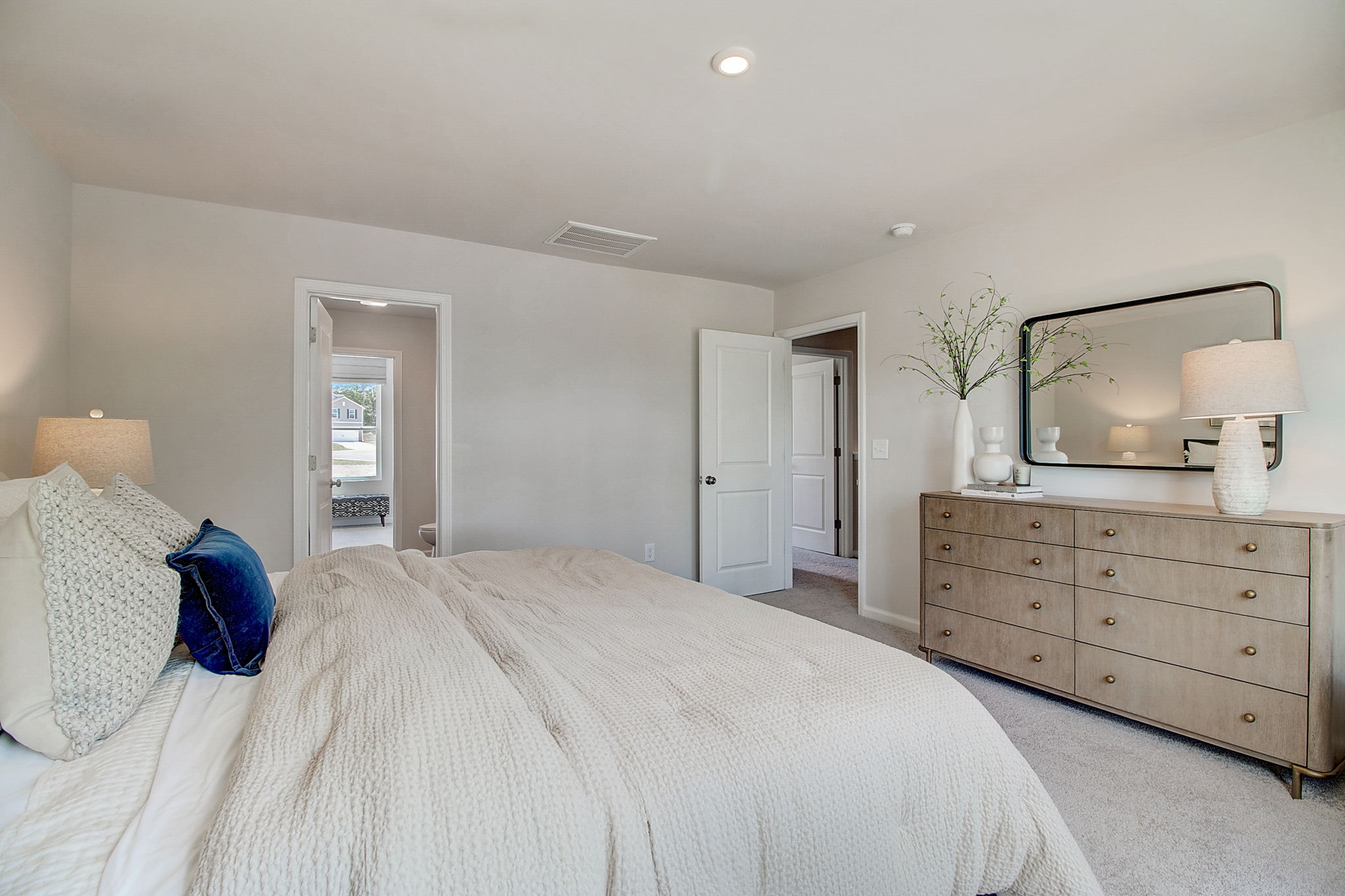 A bedroom with a bed and dresser.